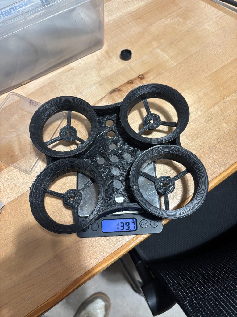 Final FGF drone frame on a digital scale reading 139.7 grams